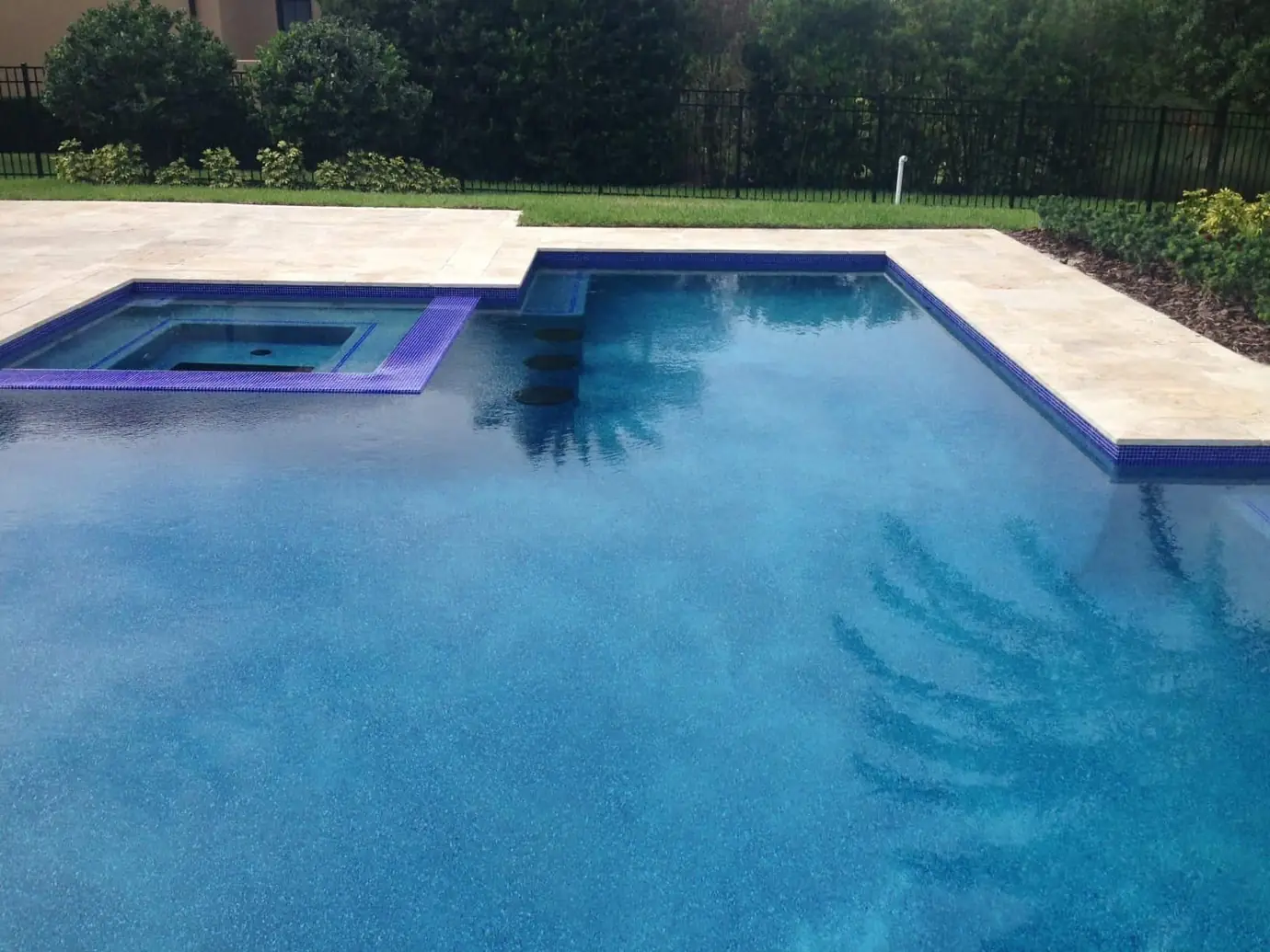 Blue pool finish with a tiled spa and travertine coping