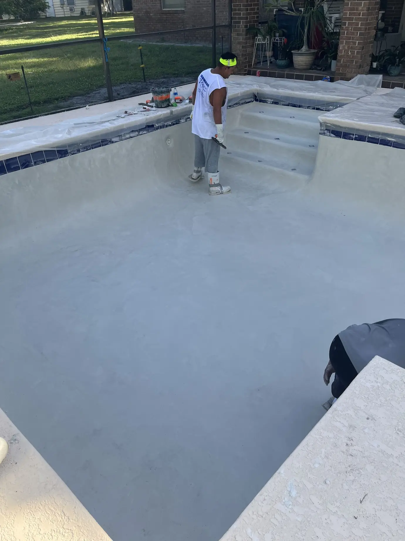 Crew finishing new plaster in an empty pool