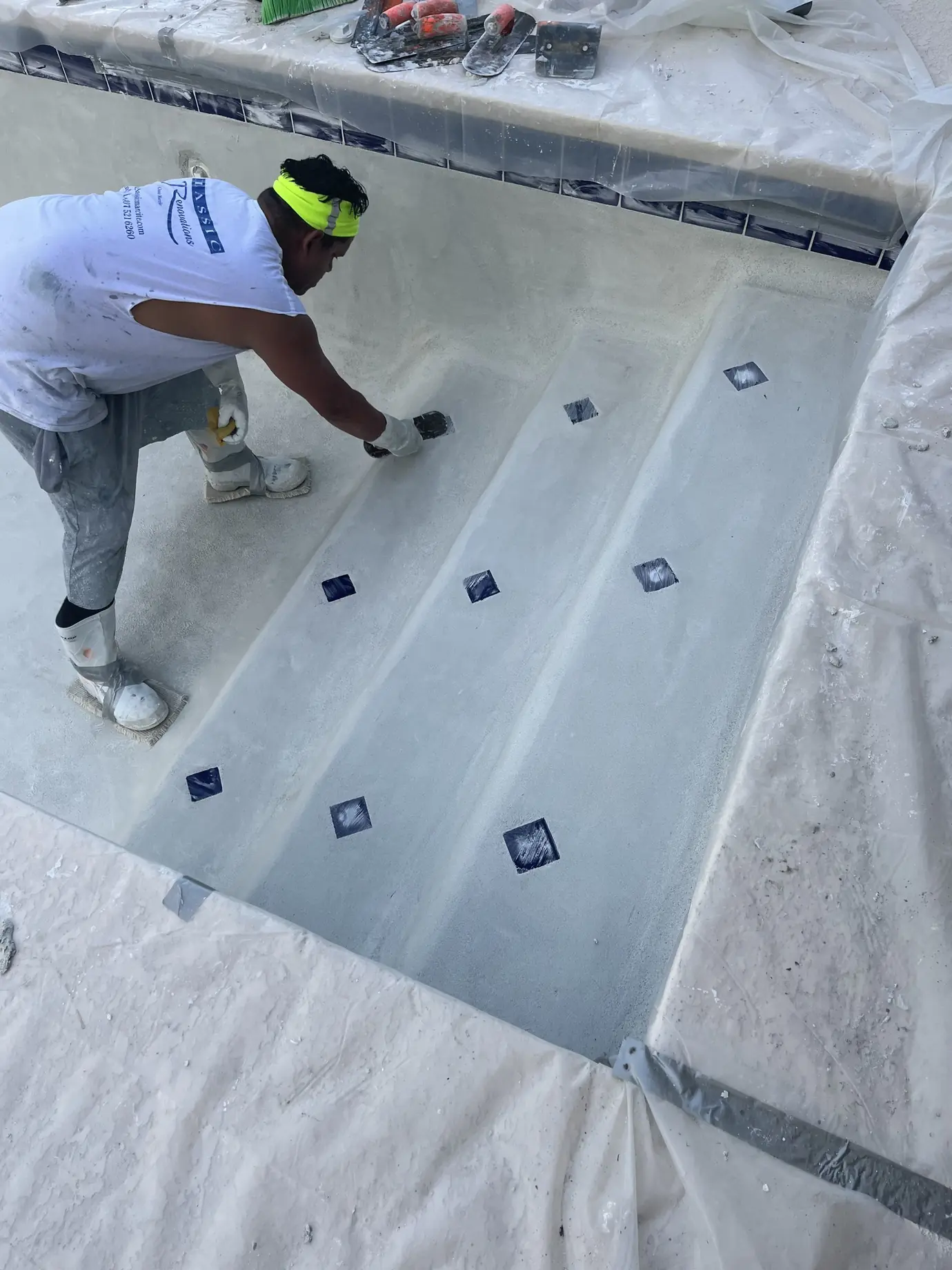 Classic Marcite crew member troweling new plaster on pool steps