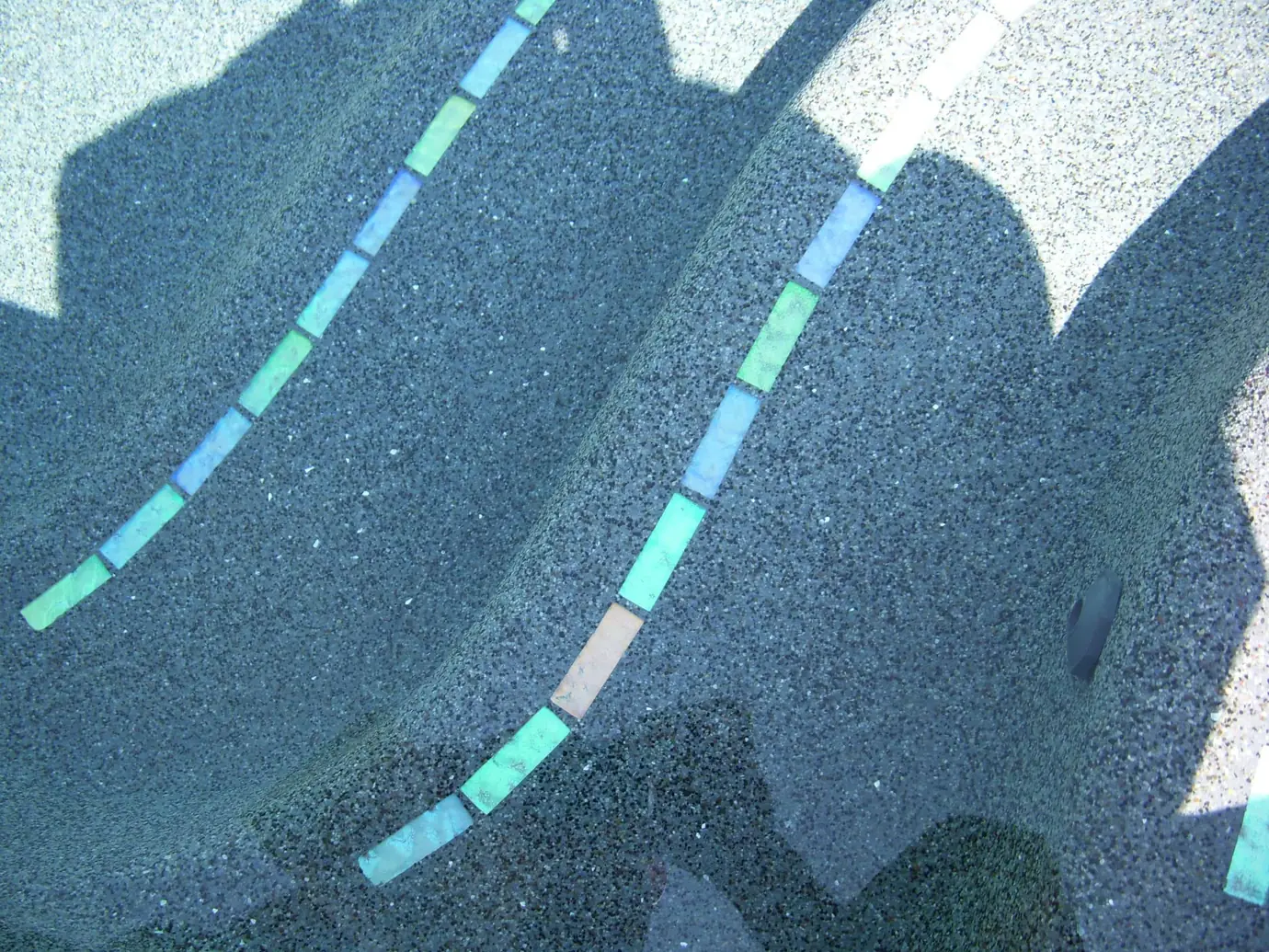 Pebble finish pool steps trimmed with glass tile