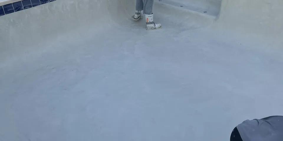 Classic Marcite crew finishing new plaster in an empty pool