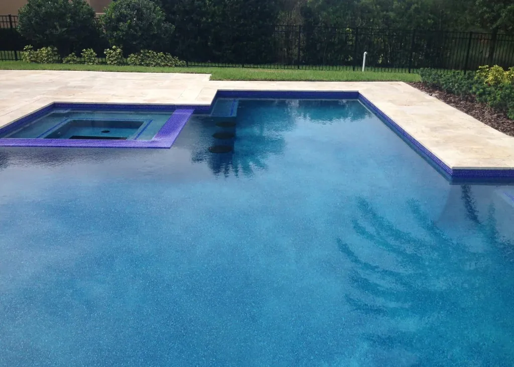 Blue pool finish with a tiled spa and travertine coping