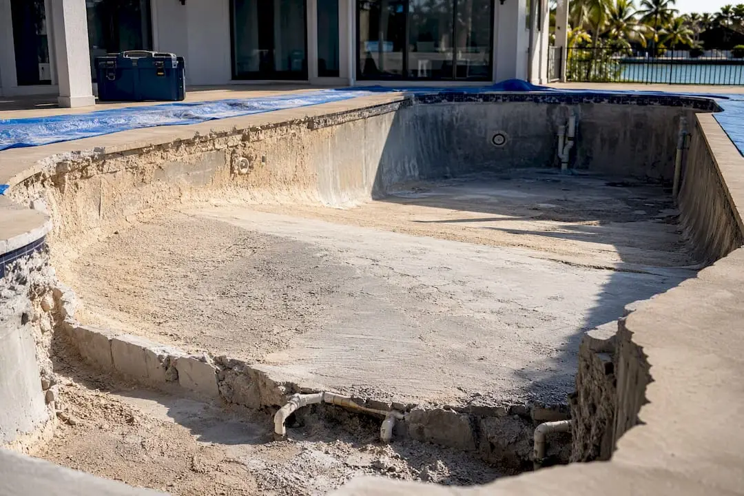 Gunite pool shell being reshaped for beach entry
