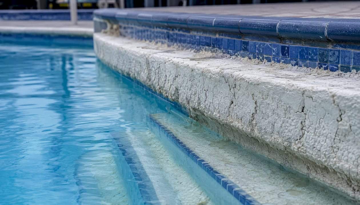 Calcium scale deposits at pool waterline and steps