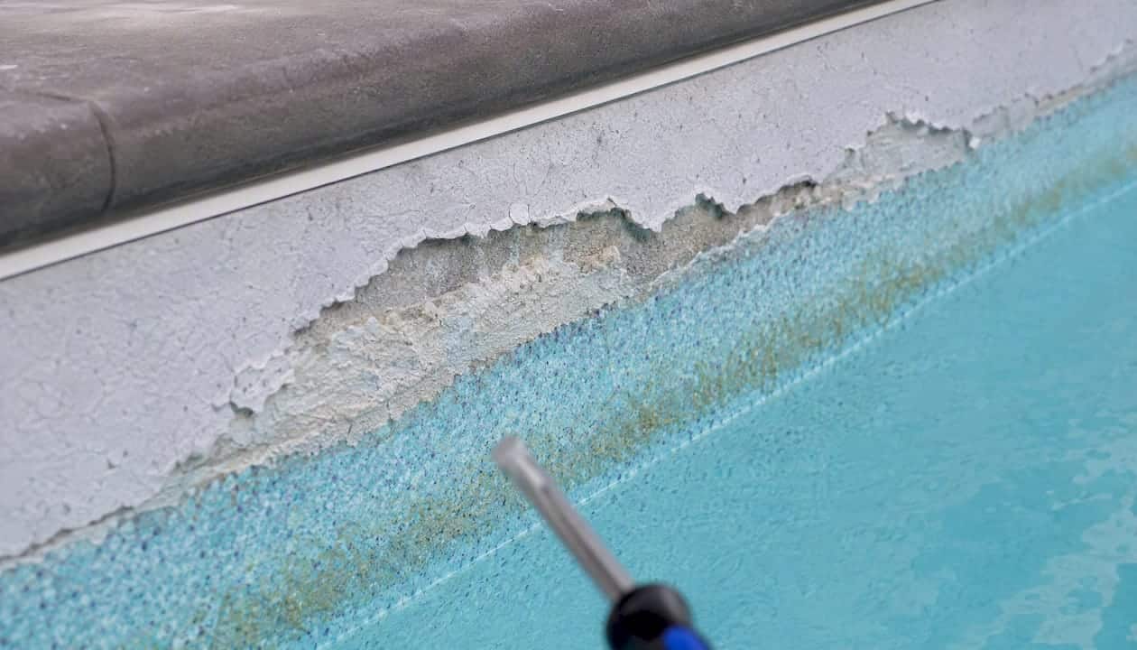 Close-up of peeling cement plaster on pool wall