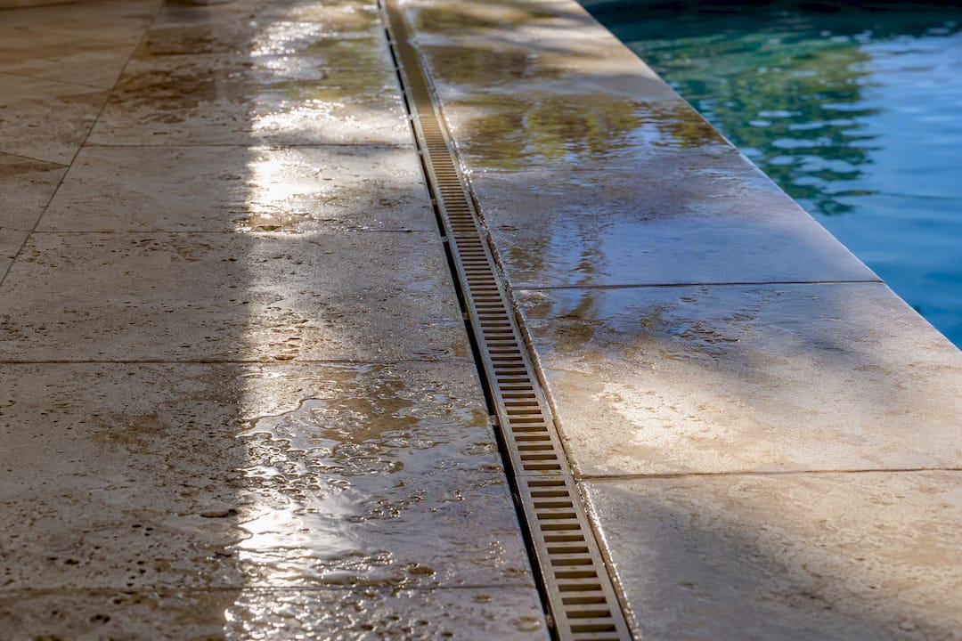 Water drainage on travertine pool deck surface