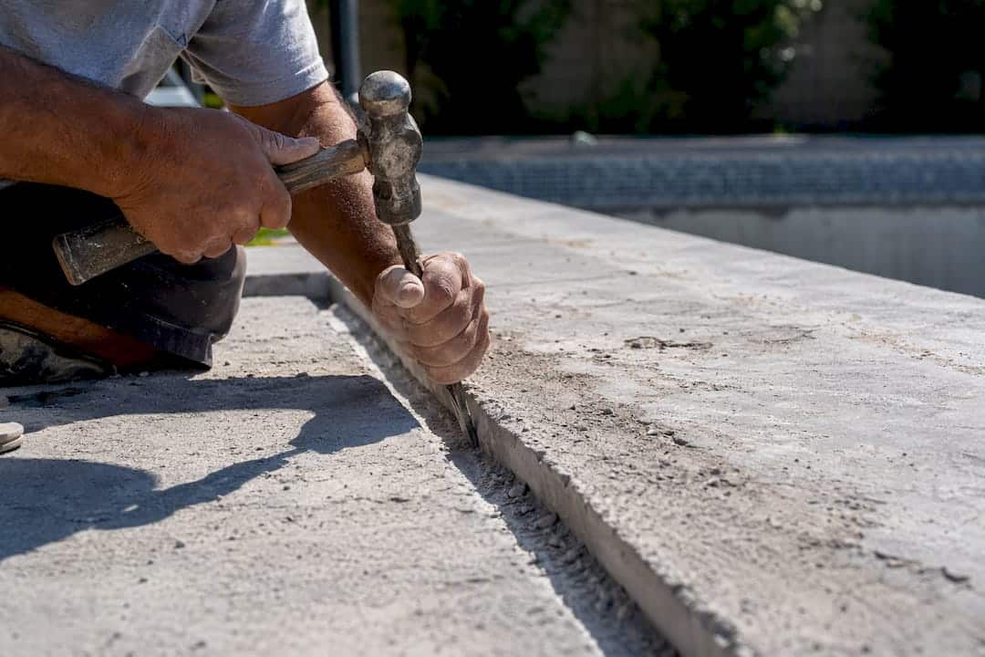 Contractor chiseling perimeter notch on pool floor
