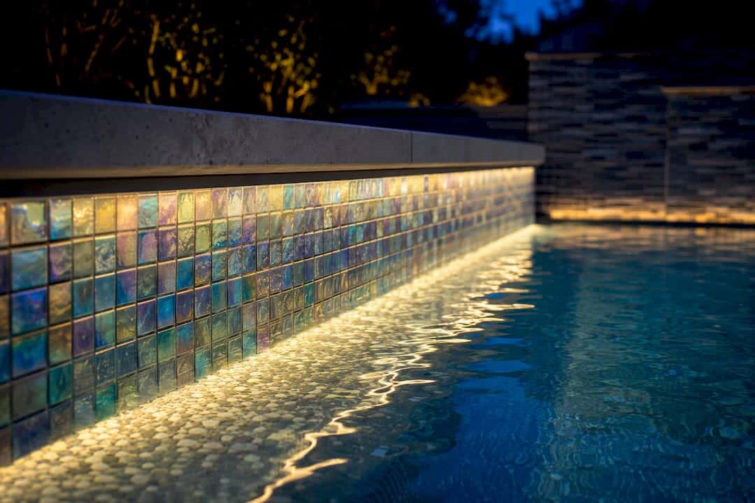 Iridescent pool tile under evening lighting