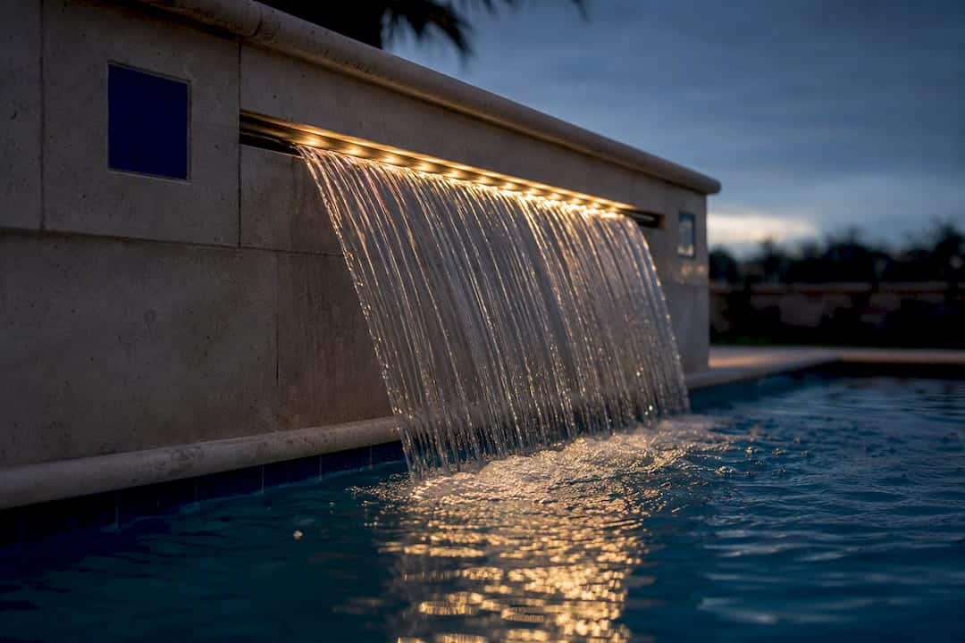 Sheer descent water curtain from pool wall